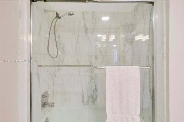 bathroom with combined bath / shower with glass door