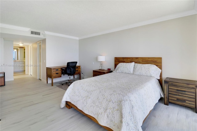 bedroom with a textured ceiling, wood-type flooring, crown molding, and ensuite bath