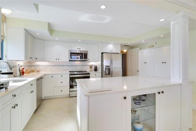 kitchen with tasteful backsplash, white cabinetry, sink, and stainless steel appliances