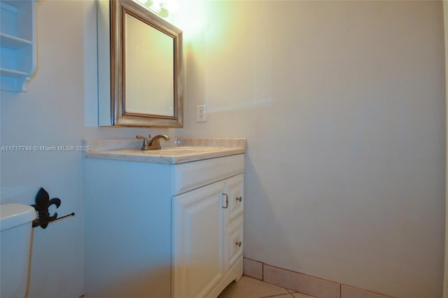 half bath featuring tile patterned flooring, vanity, toilet, and baseboards