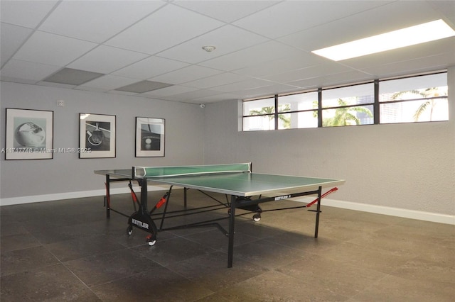 game room featuring a drop ceiling and baseboards