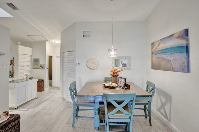 dining area with baseboards, visible vents, and light wood finished floors