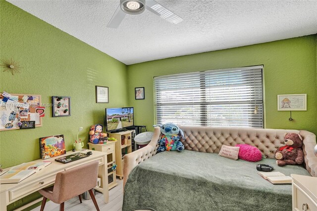 bedroom featuring a textured ceiling, light hardwood / wood-style floors, and ceiling fan