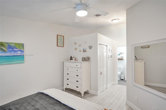 bedroom with light wood finished floors, visible vents, connected bathroom, ceiling fan, and baseboards