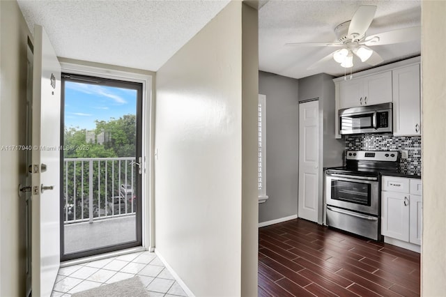 1402 NW 80th Ave Unit 410, Margate, FL 33063 - kitchen featuring stainless steel appliances, backsplash, a textured ceiling, a ceiling fan, and white cabinets