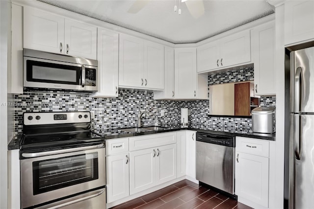 kitchen featuring backsplash, sink, ceiling fan, white cabinetry, and stainless steel appliances