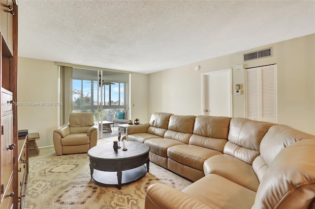 living room featuring floor to ceiling windows and a textured ceiling