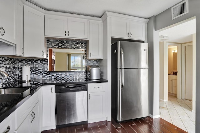 1402 NW 80th Ave Unit 410, Margate, FL 33063 - kitchen featuring appliances with stainless steel finishes, dark countertops, dark wood-style flooring, tasteful backsplash, and white cabinets