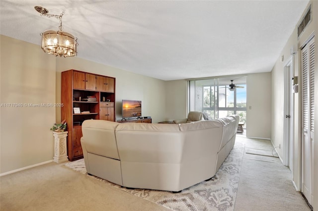 living room with ceiling fan with notable chandelier and light colored carpet