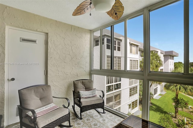 1402 NW 80th Ave Unit 410, Margate, FL 33063 - sunroom / solarium featuring a textured wall, ceiling fan, a textured ceiling, and a wall of windows
