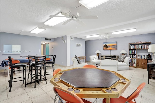 playroom featuring ceiling fan, light tile patterned floors, and a textured ceiling