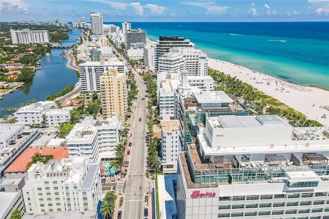 birds eye view of property featuring a beach view and a water view