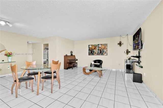 tiled dining room featuring a textured ceiling