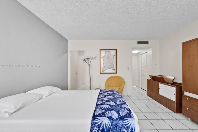 tiled bedroom featuring a textured ceiling and a closet