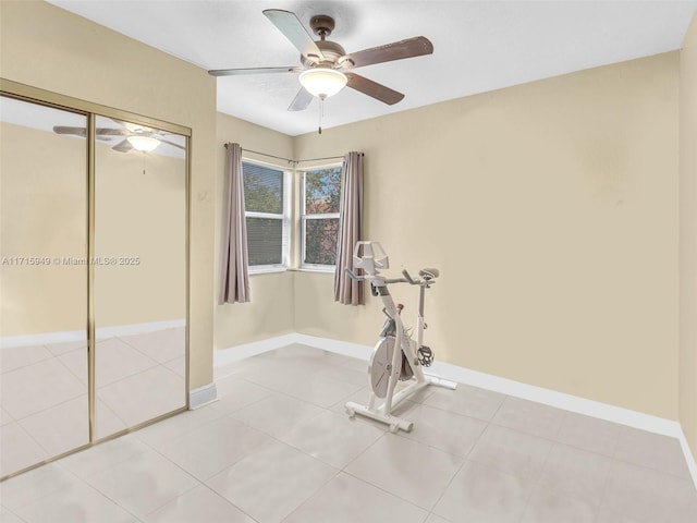 workout room with ceiling fan and light tile patterned floors