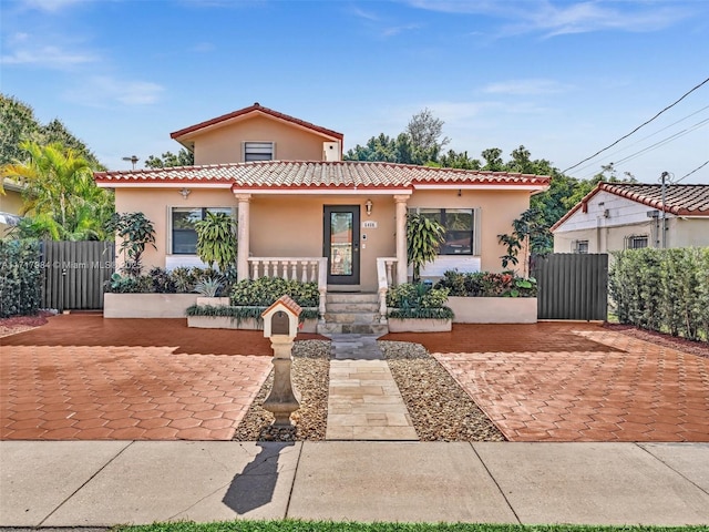 mediterranean / spanish home featuring covered porch