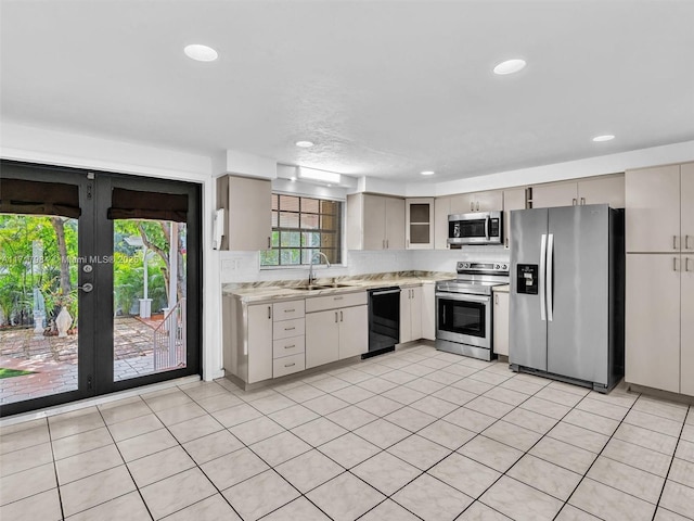 kitchen featuring appliances with stainless steel finishes, light tile patterned floors, french doors, and sink