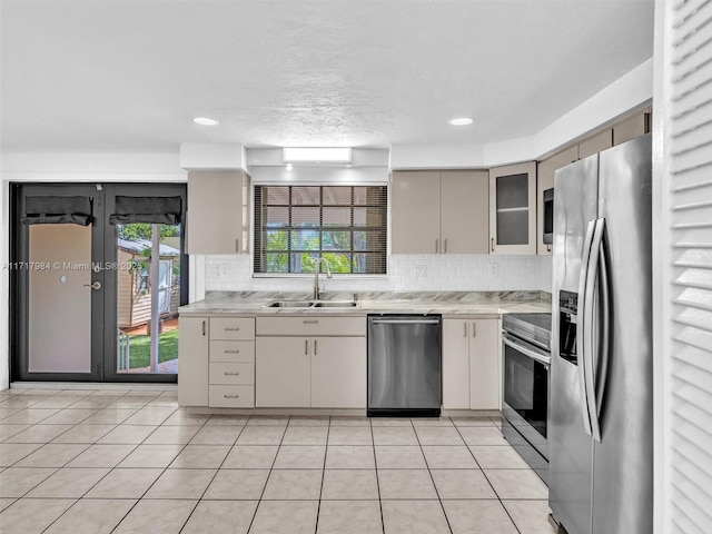 kitchen featuring sink, light tile patterned floors, stainless steel appliances, and tasteful backsplash