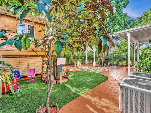 view of yard with cooling unit and a patio area