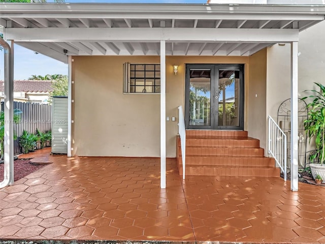 view of exterior entry with a patio area and french doors