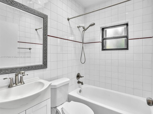 full bathroom featuring vanity, toilet, tile walls, and tiled shower / bath combo