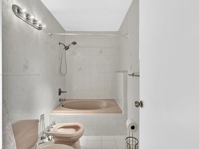 bathroom with tiled shower / bath, tile patterned floors, a bidet, and toilet