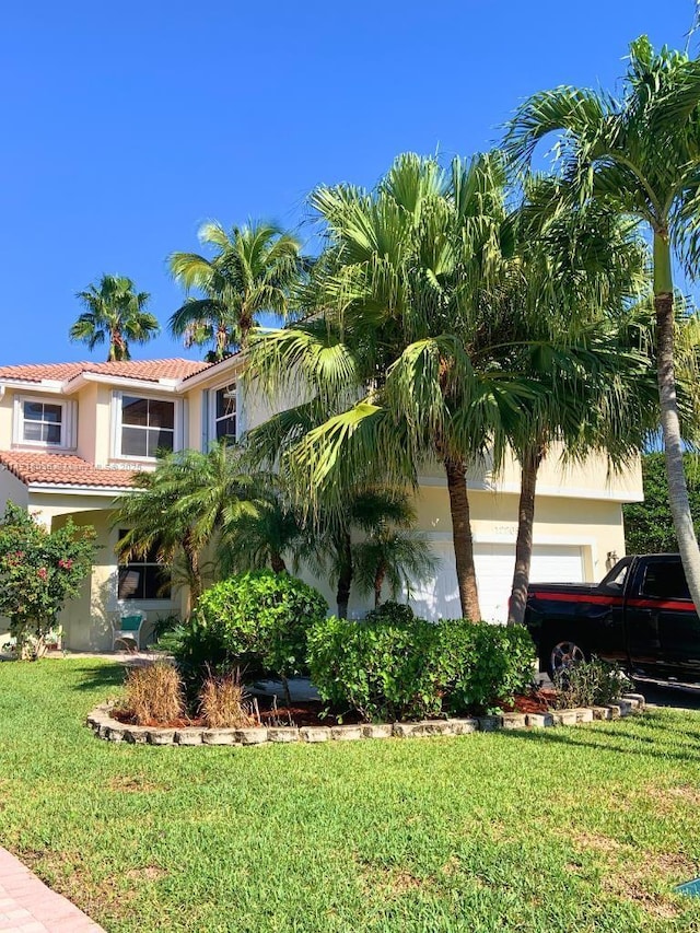 view of front of property featuring a garage and a front lawn