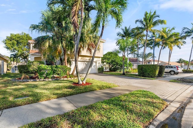 view of front of house featuring a garage and a front lawn