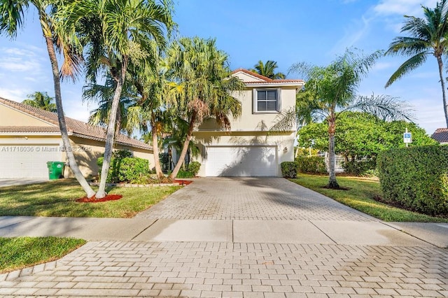 mediterranean / spanish-style house featuring a garage and a front yard