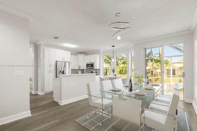 dining room with dark wood-type flooring, an inviting chandelier, and ornamental molding