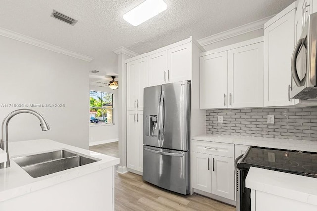 kitchen with ceiling fan, sink, a textured ceiling, white cabinets, and appliances with stainless steel finishes