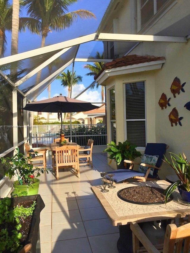 view of patio featuring glass enclosure