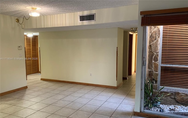 tiled empty room with a textured ceiling