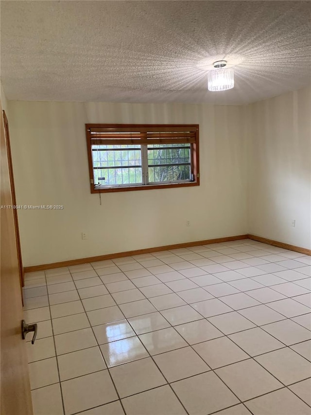 tiled empty room with a textured ceiling