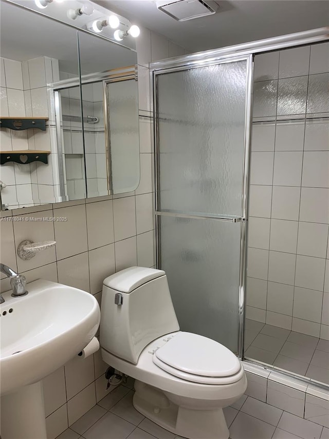 bathroom featuring tile walls, tile patterned floors, toilet, and walk in shower