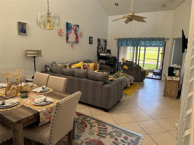 tiled living room with high vaulted ceiling and ceiling fan with notable chandelier