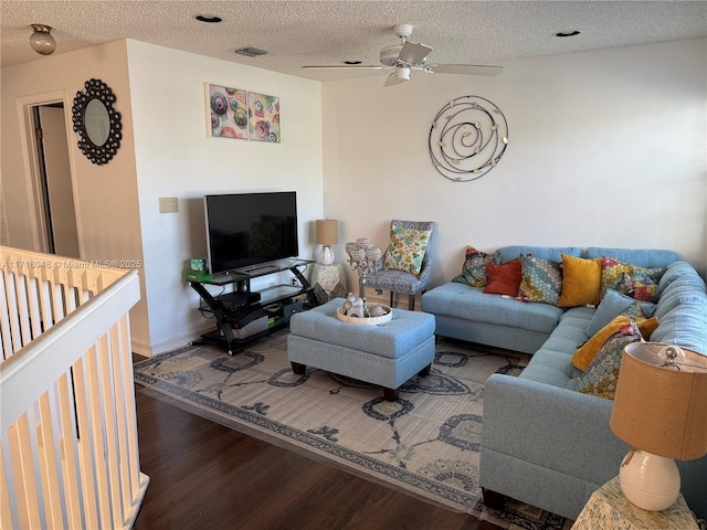 living room featuring a textured ceiling, dark hardwood / wood-style flooring, and ceiling fan