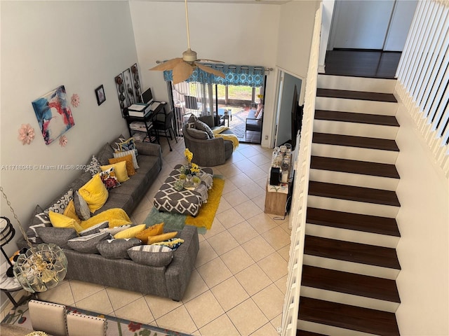 living room featuring a towering ceiling, tile patterned floors, and ceiling fan