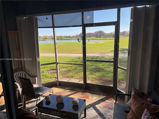 sunroom / solarium featuring a water view