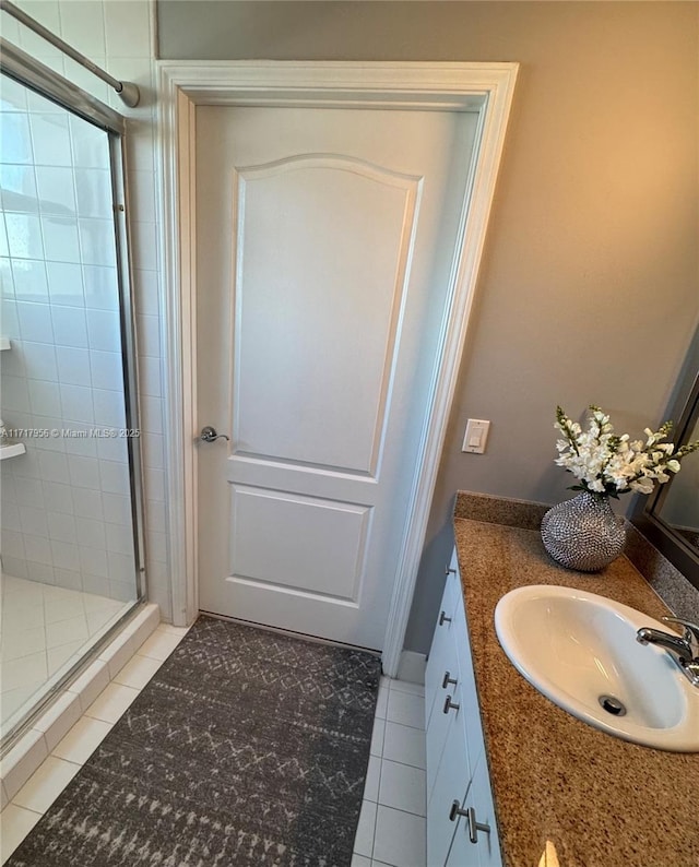 bathroom featuring tile patterned flooring, vanity, and an enclosed shower