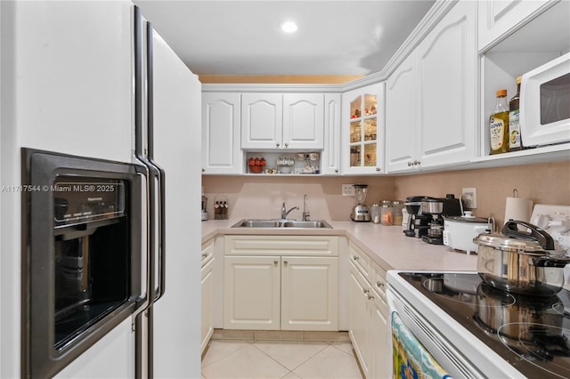 kitchen featuring white cabinets, light tile patterned floors, white appliances, and sink