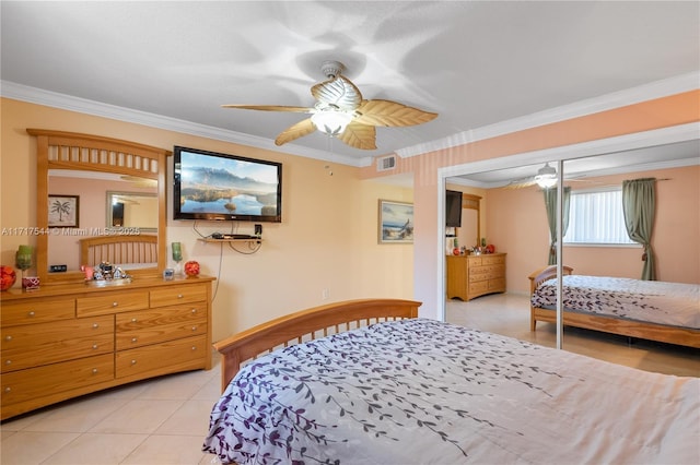 bedroom with light tile patterned floors, a closet, ceiling fan, and ornamental molding