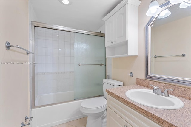 full bathroom featuring tile patterned floors, vanity, bath / shower combo with glass door, and toilet