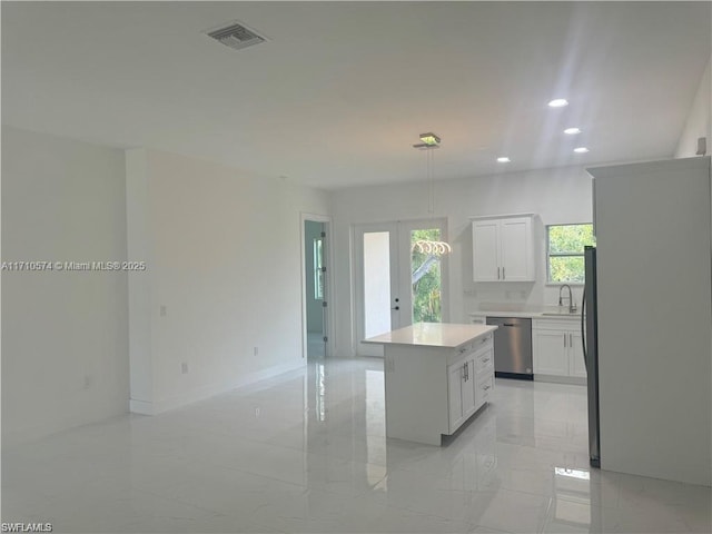 kitchen with french doors, stainless steel dishwasher, a center island, white cabinetry, and fridge