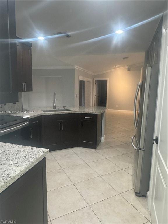 kitchen featuring light stone counters, sink, light tile patterned floors, and appliances with stainless steel finishes