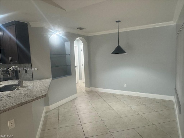 unfurnished dining area with light tile patterned floors, crown molding, and sink