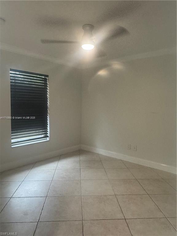 unfurnished room with crown molding and light tile patterned flooring