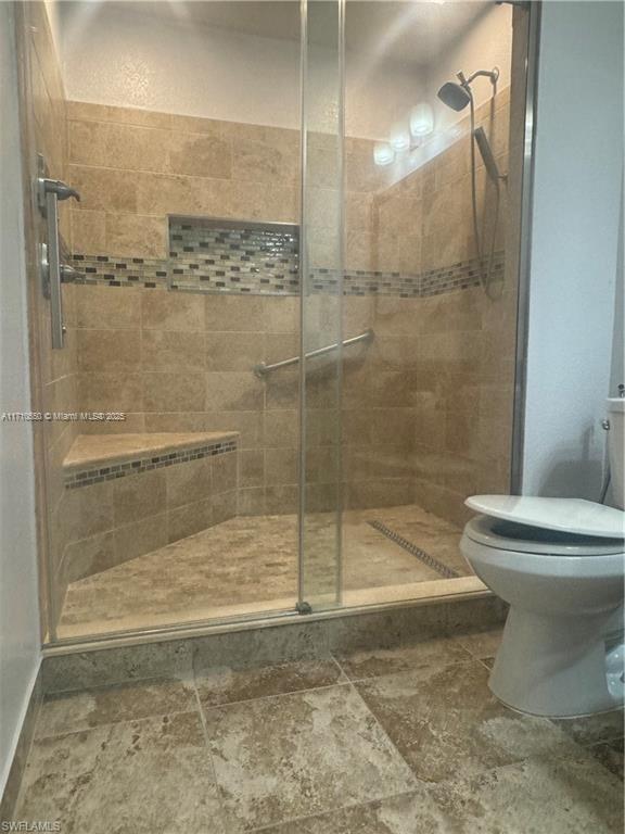 bathroom featuring toilet and walk in shower