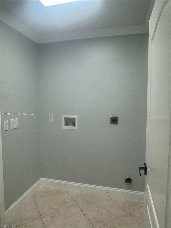 clothes washing area with hookup for an electric dryer, light tile patterned floors, crown molding, and washer hookup