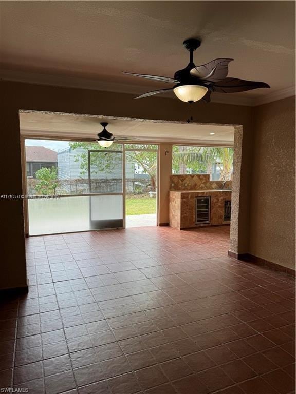 spare room featuring crown molding and ceiling fan